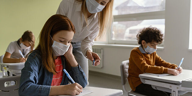 children-with-medical-masks-studying-school-with-teacher