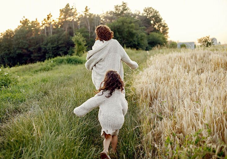 Mother with daughter playing in a summer field