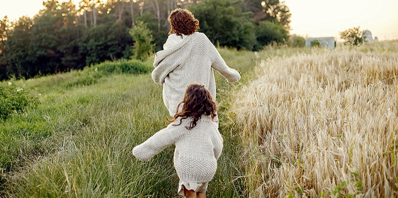 Mother with daughter playing in a summer field