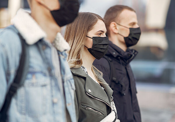 People in a masks stands on the street